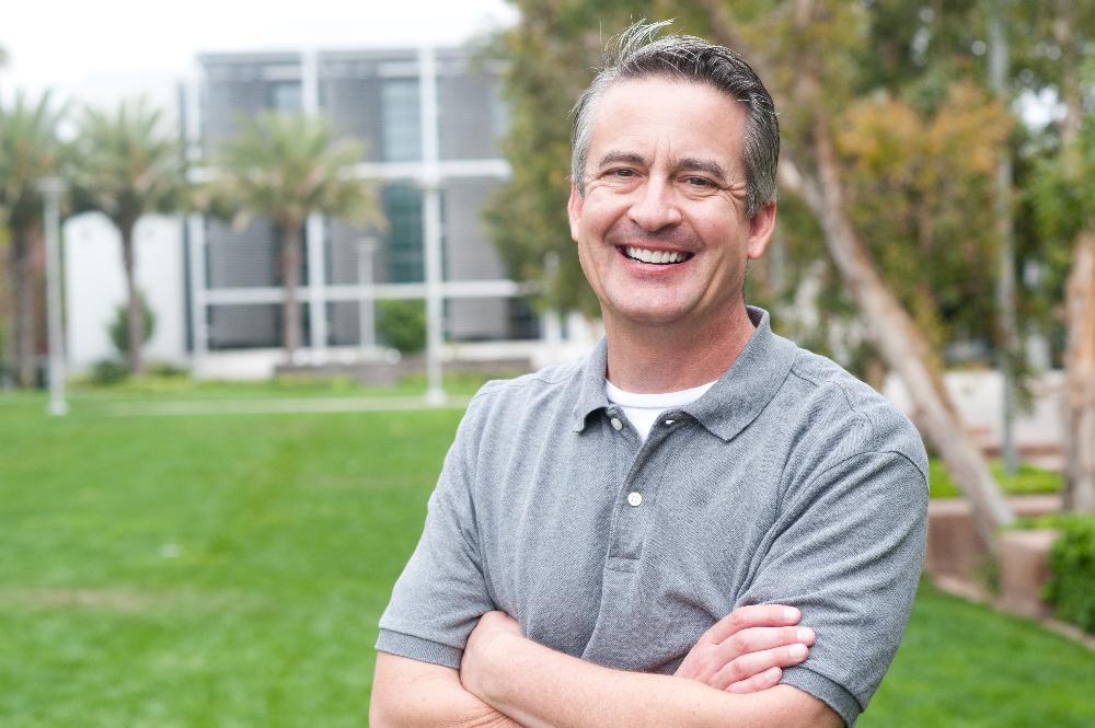 man smiling with palm tree in the background | family dentistry kauai