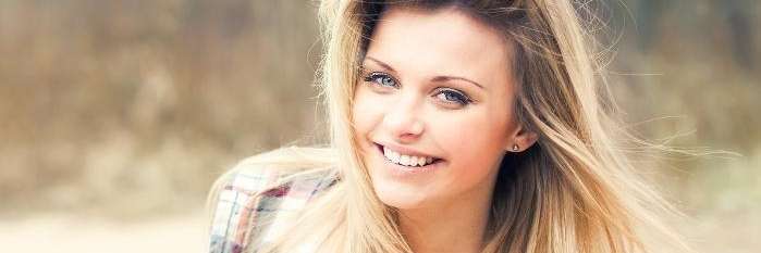 A woman smiling in plaid shirt | dentist Poipu