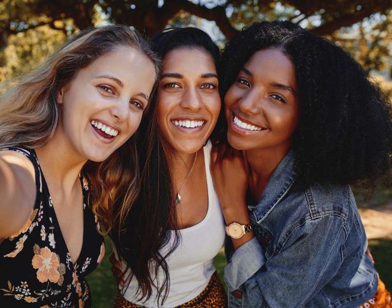 three women hugging outside | cosmetic dentist kauai