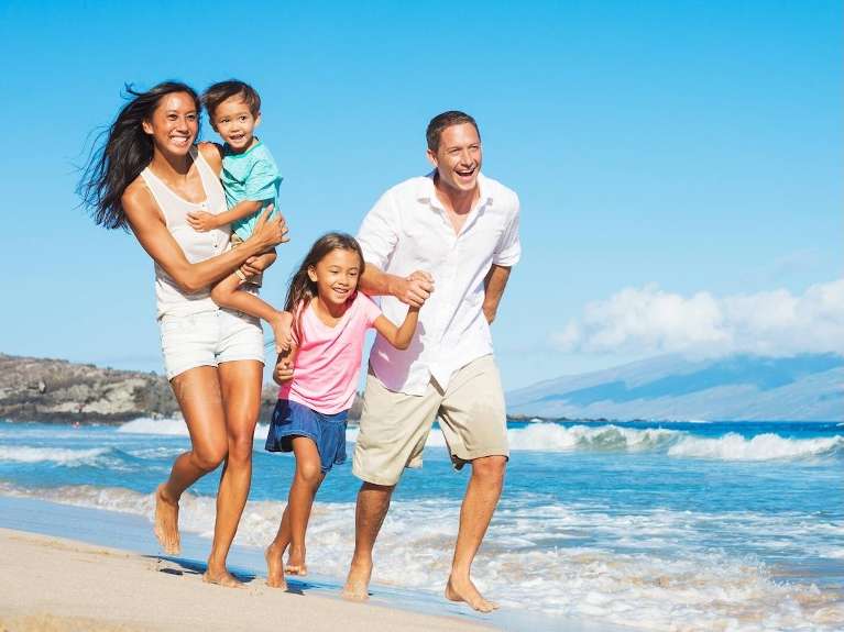 family of four walking on beach | family dentistry kauai